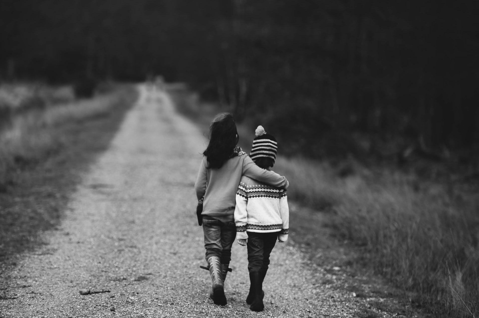 two young girls walking together down a road